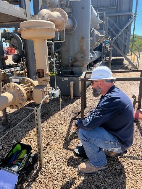 MRI field technician inspecting instrumentation at a valve