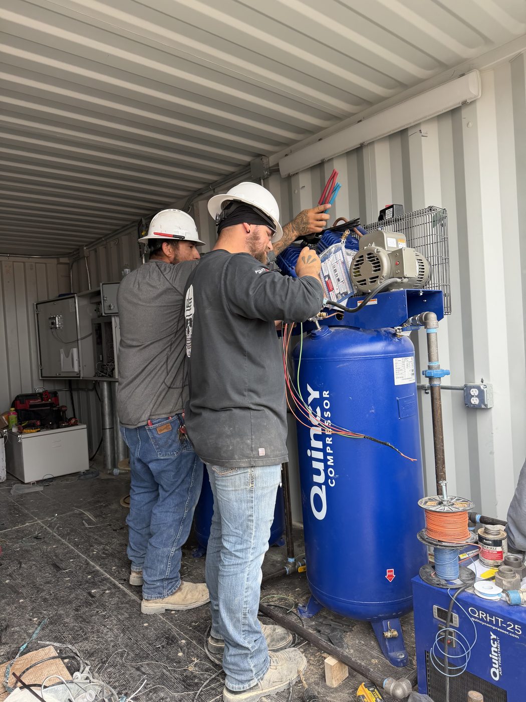 MRI field technicians wiring a compressor installation